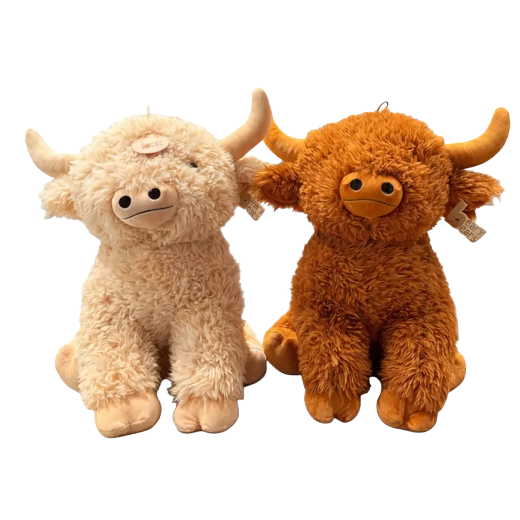 Two Highland bull plush toys in beige and brown sitting side by side on a white background
