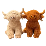 Two Highland bull plush toys in beige and brown sitting side by side on a white background