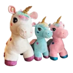 Three plush unicorn toys in cream, blue and pink with golden horns, rainbow manes and shiny hooves.