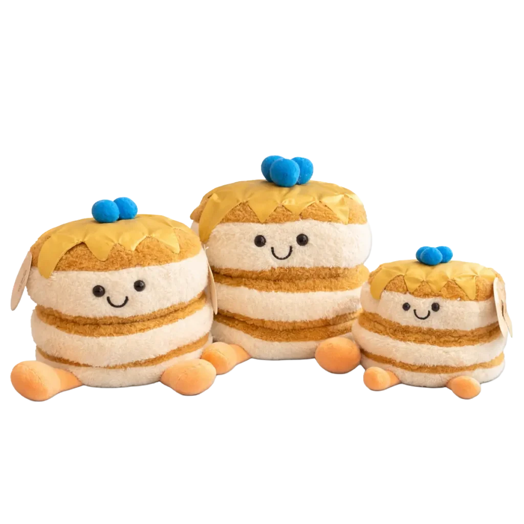 Three smiling pancake plush toys with syrup topping and blueberries, shown in three different sizes on a white background.