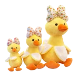 Yellow duck plush assortment with large decorative bows, orange beaks and feet, shown in three different sizes.