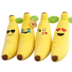 Four assorted banana emoji plush toys with different expressions including sunglasses, laughing, kiss face and heart eyes.