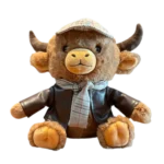 Plush highland cow wearing a cap, scarf and brown coat, sitting against a white background.