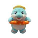 Light blue plush dolphin with a yellow cap and orange swimming ring with stars, standing against a white background.