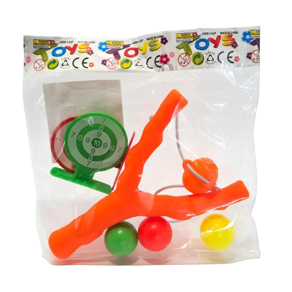 Toy slingshot set with orange plastic slingshot, three colorful balls, and small target game in clear retail bag packaging.